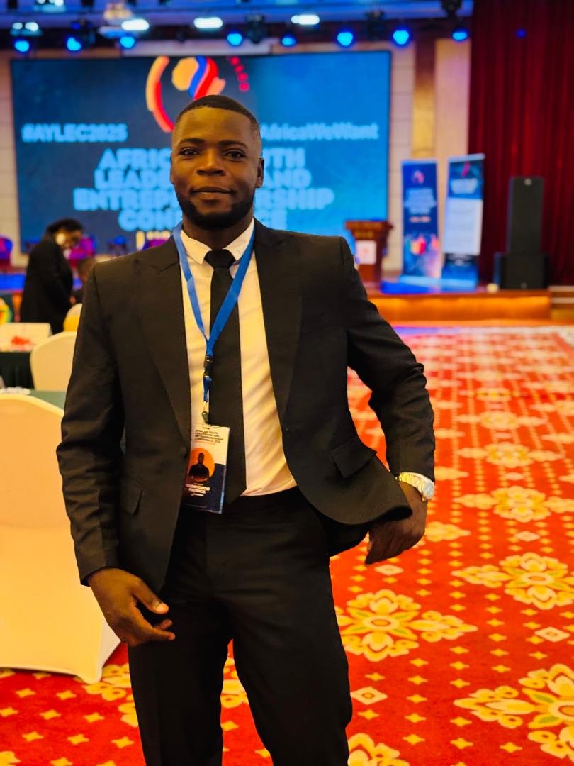Patrick Ssenyondo, founder of Light the Future Foundation, standing proudly with children