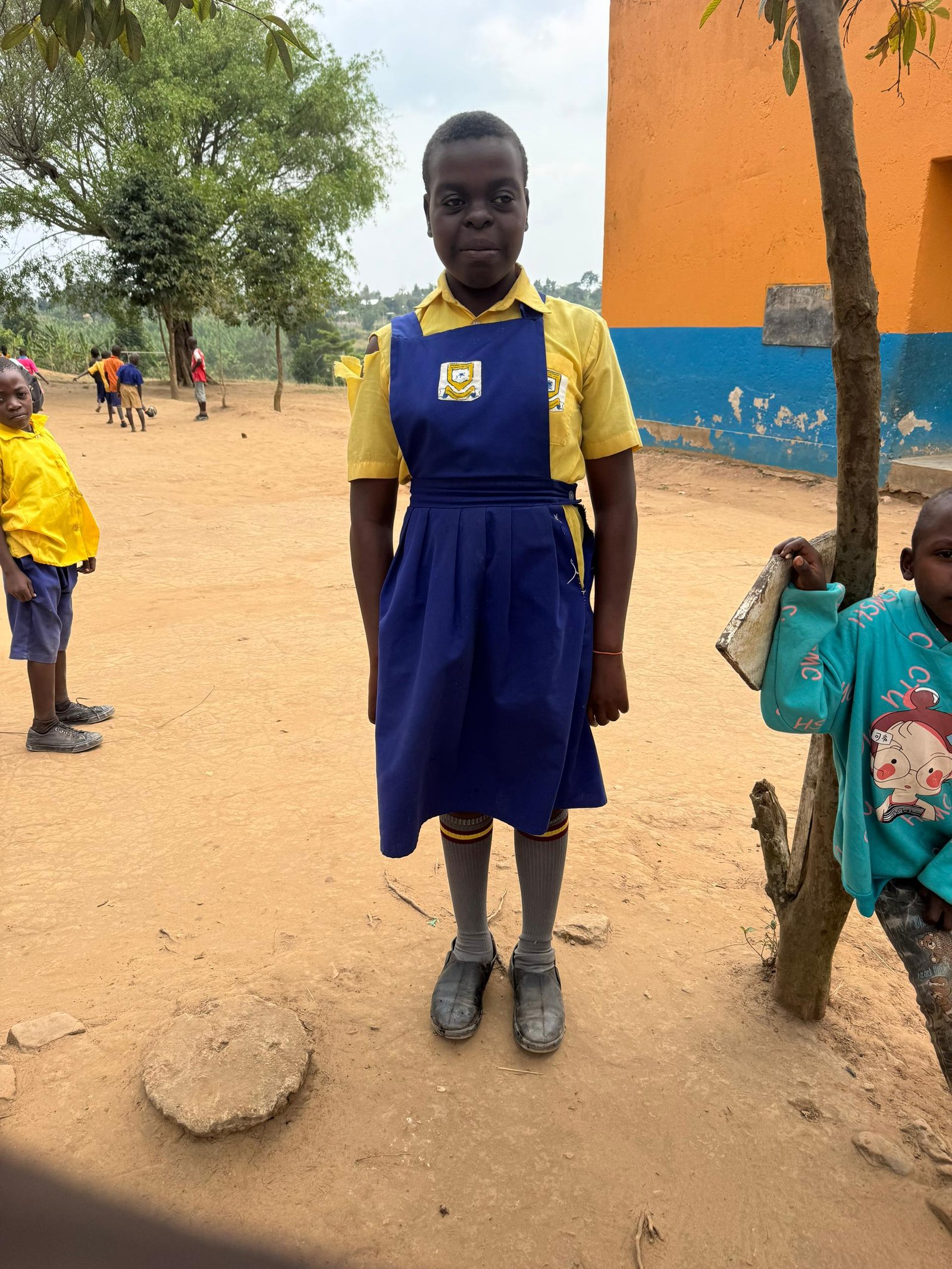 Namata, a 12-year-old girl holding a book and smiling confidently